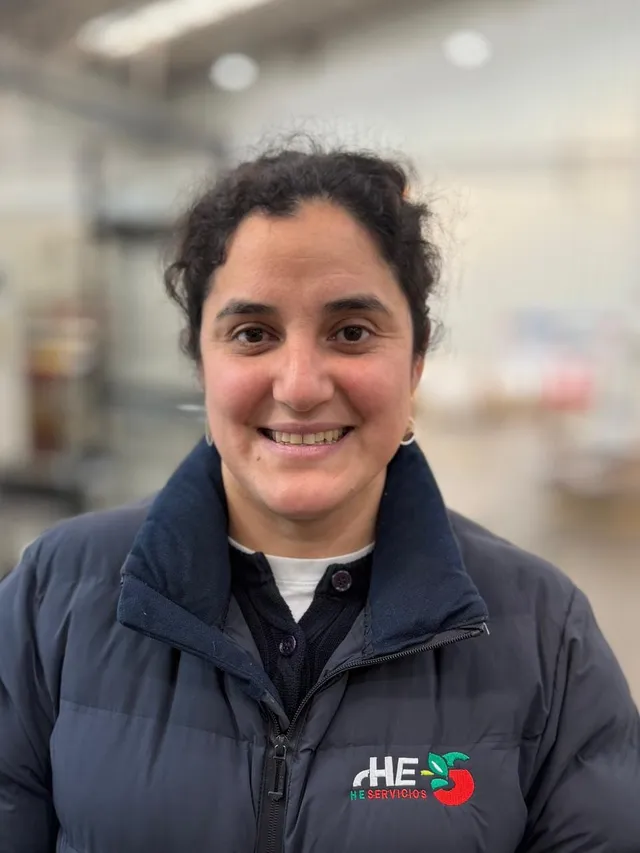 Retrato de Mabel Hernández en la planta de packing, con la chaqueta corporativa de la empresa